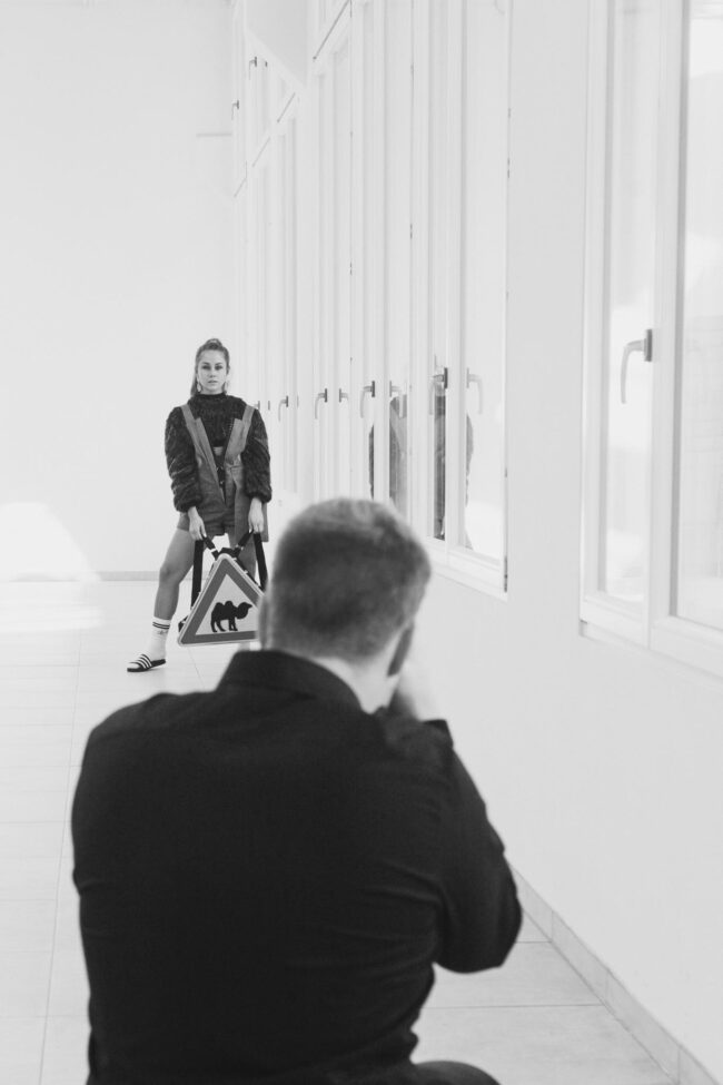 Fashionshooting, Fotograf steht mit Rücken zur Kamera und fotografiert Model, Schwarz-Weiß