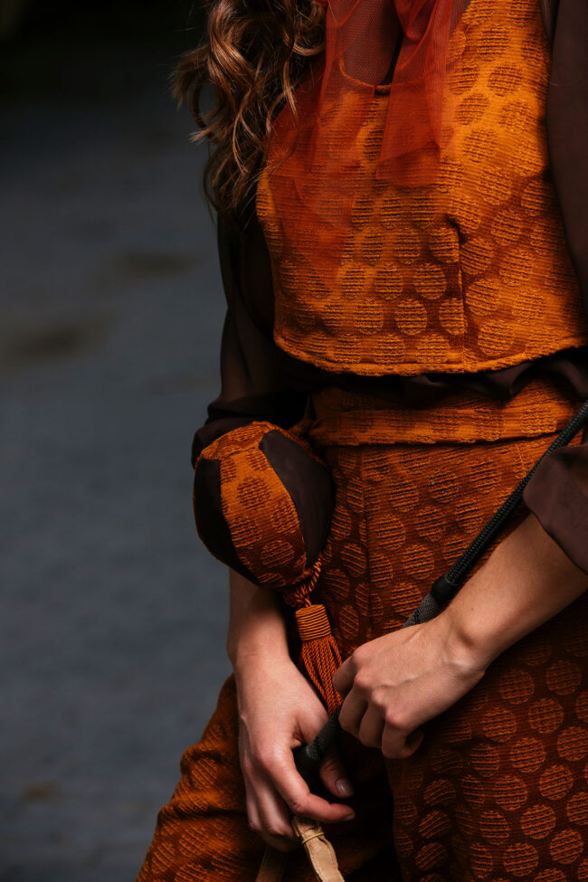 Fashion, Model in orangenem Kostüm, Nahaufnahme, ohne Gesicht