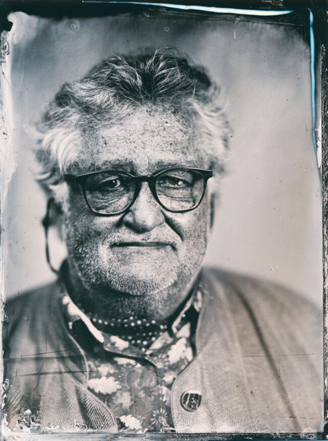 Nassplatte, Schwarz-Weiß, Portraitaufnahme von älteren Mann mir mittellangen grauen Haaren und schwarzer Brille