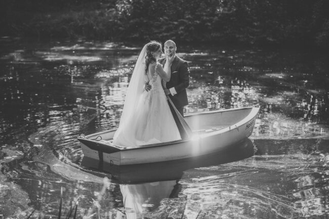 Hochzeit, Portrait, Brautpaar steht in Ruderboot auf einem See, schwarz-weiß