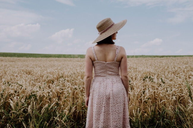 Portrait, Frau mit Hut vor Feld