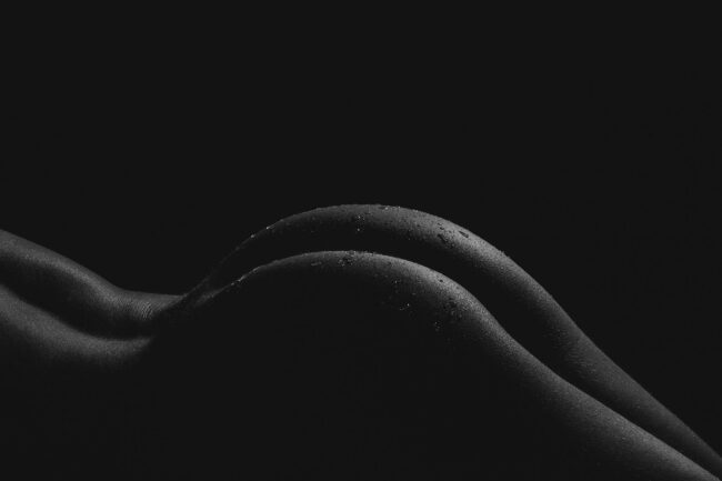 Sensual, Bodypart Po mit Wassertropfen auf der Haut, Nahaufnahme, Schwarz-Weiß