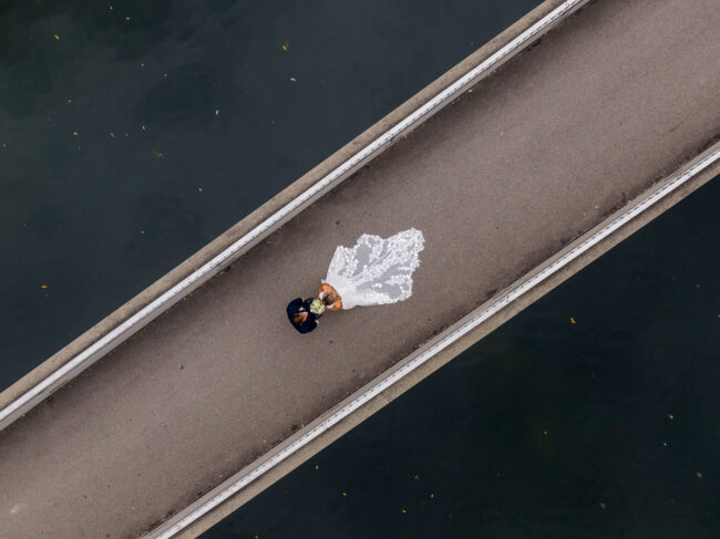 Hochzeit, Brautpaar auf einer Brücke, sich anschauend, Drohnenaufnahme, Querformat