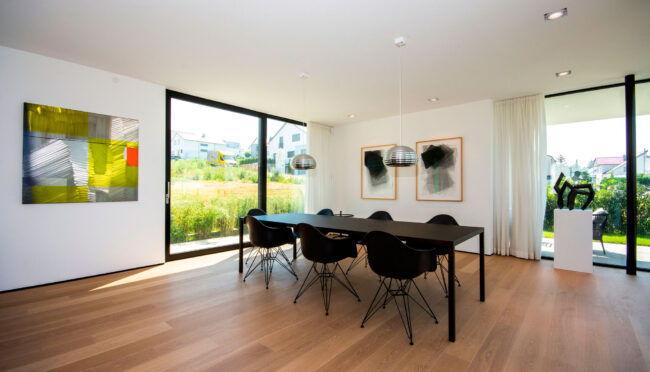 Architektur, Innenaufnahme geräumiger Essbereich mit bodentiefen Fenstern, Parkettboden und matt-schwarzen Esstisch und Stühlen