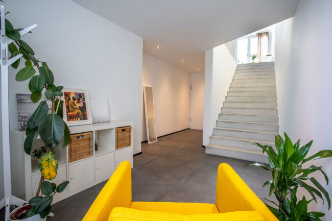 Architektur, Interieuraufnahme Treppenaufgang, davor Sitzgelegenheiten und Grünpflanzen