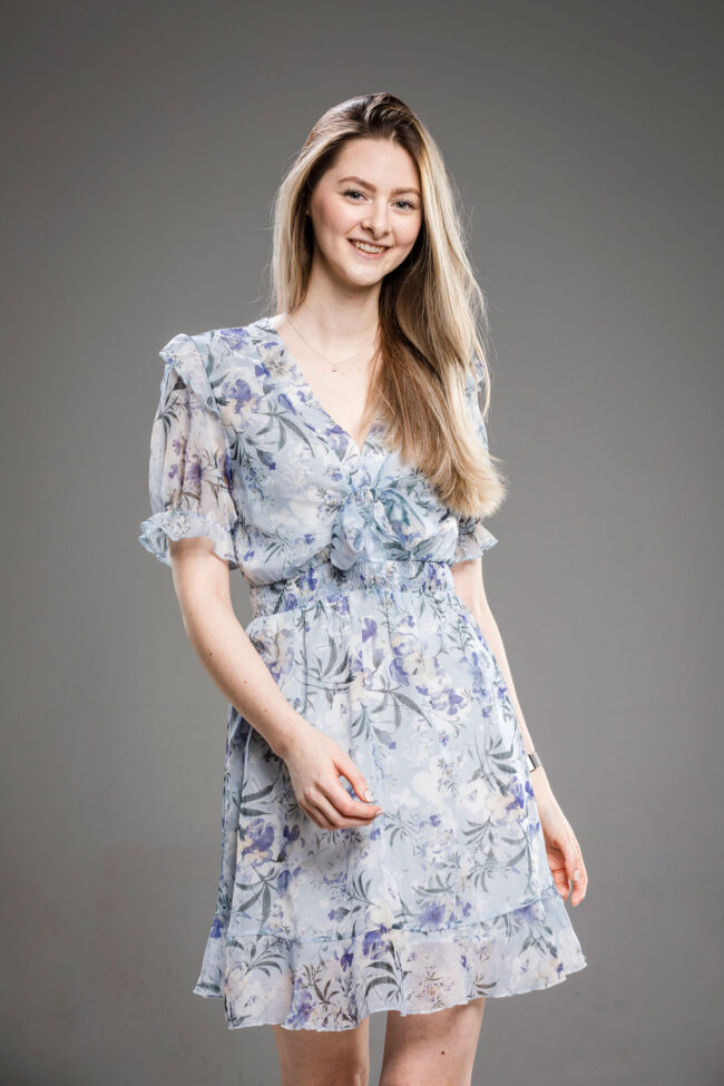 Portrait, Junge Frau in blau-geblümten Kleid lächelt in die Kamera