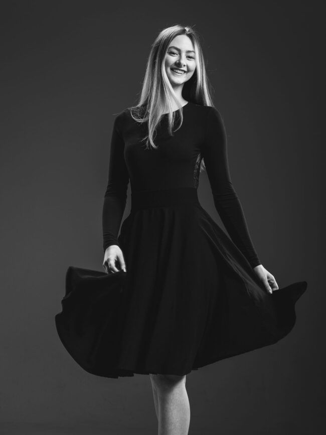 Portrait, Junge Frau im Kleid in Drehung lächelt in die Kamera, Schwarz Weiß