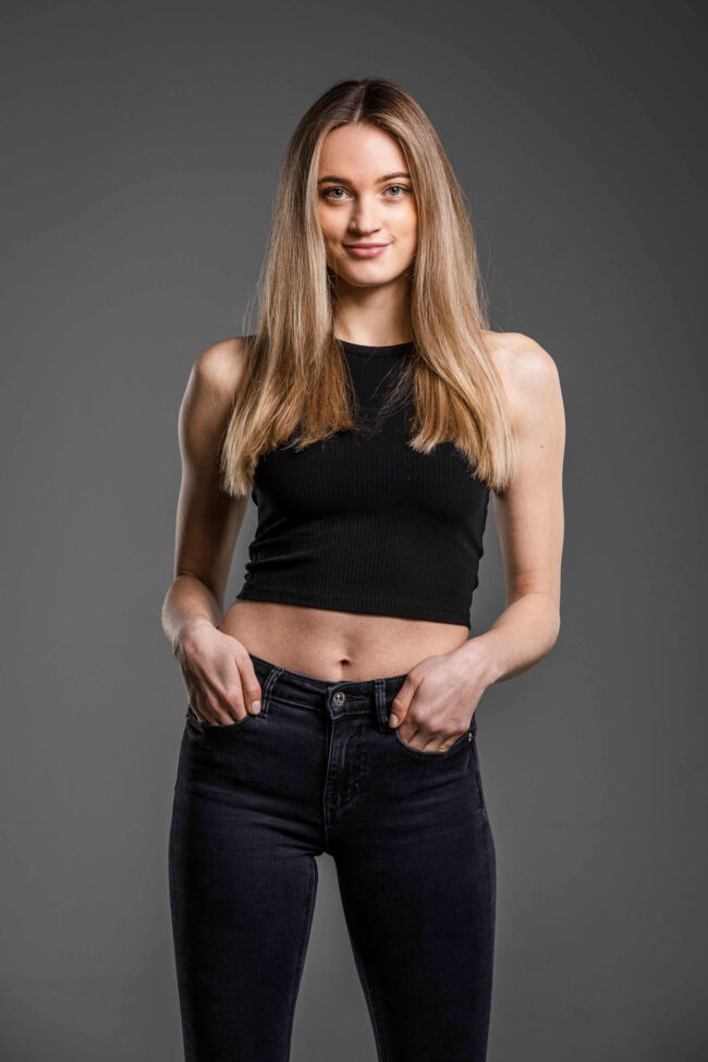 Portrait, Junge Frau stehend mit Händen in den Hosentaschen, Halbportrait