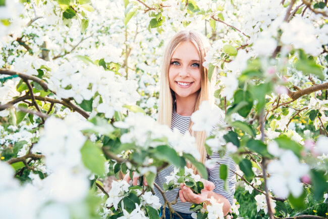 Portrait, junge Frau zwischen weiß-blühenden Bäumen, Halbportrait