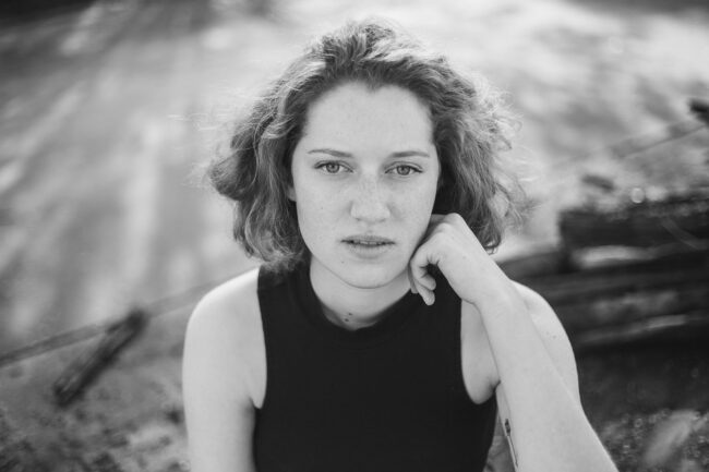 Portrait, Frau stützt Gesicht auf Hand auf, Nahaufnahme, Schwarz-Weiß