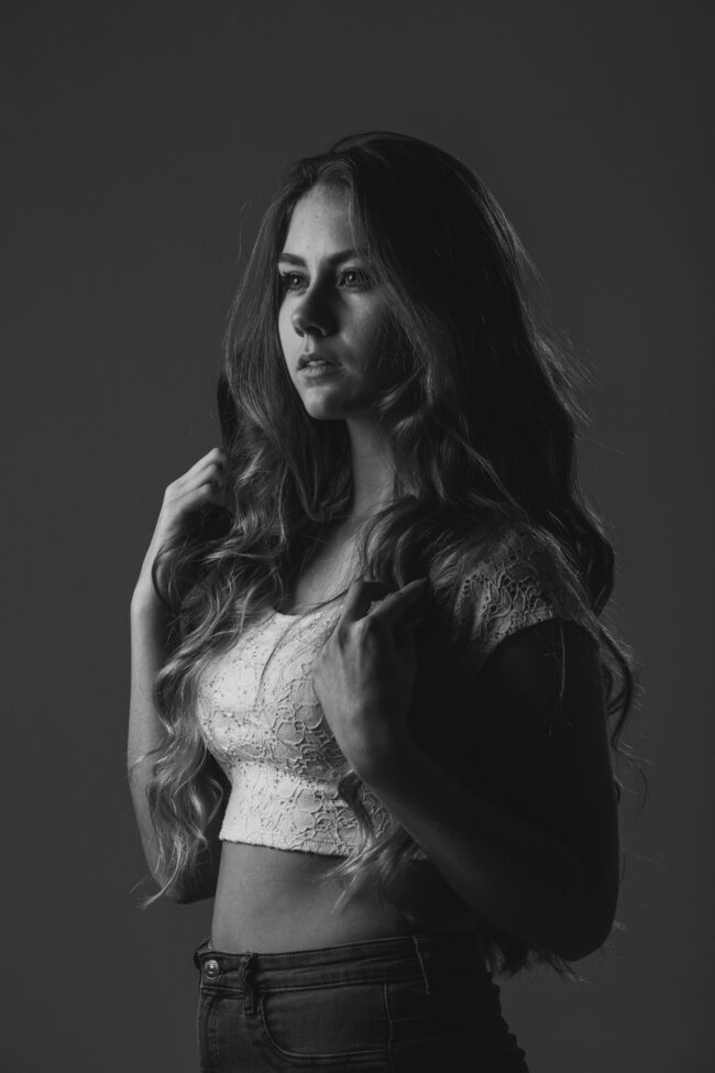 Portrait, junge Frau in weißem Spitzentop und langen Haaren, Schwarz Weiß, Halbportrait