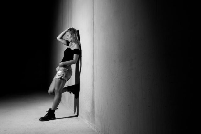 Portrait, Frau lehnt sich gegen Wand, Schwarz Weiß, Ganzaufnahme