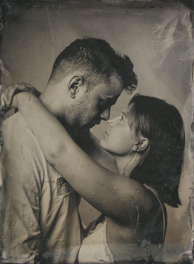 Nassplatte, Schwarz-Weiß, Portraitaufnahme von einem Paar, dass sich im Arm hält und anschaut, die Nasen berühren sich
