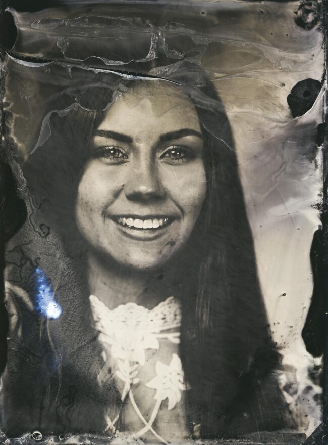 Nassplatte, Schwarz-Weiß, Portraitaufnahme von lachender jungen Frau mit langen, dunklen Haaren