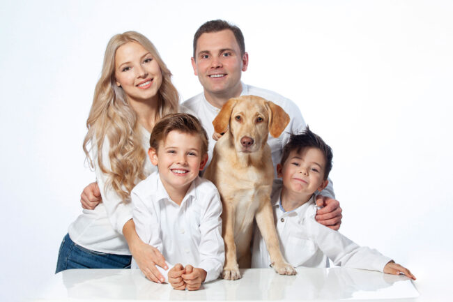 Familie, 4 Personen mit Hund, in weißen Hemden, vor weißem Hintergrund