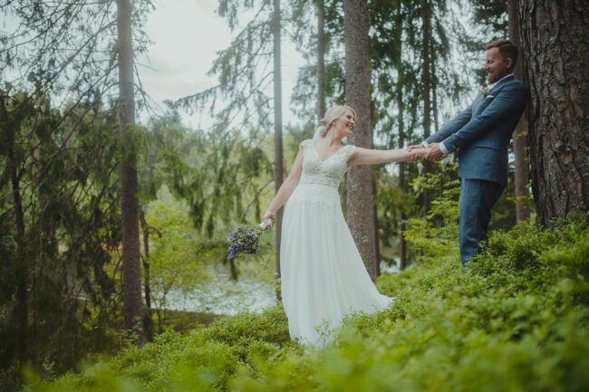 Hochzeit, Brautpaar im Wald, Bräutigam zieht Braut zu sich