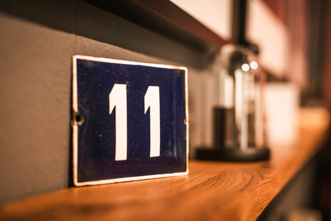 Detailaufnahme, blaues Schild mit der Hausnummer 11