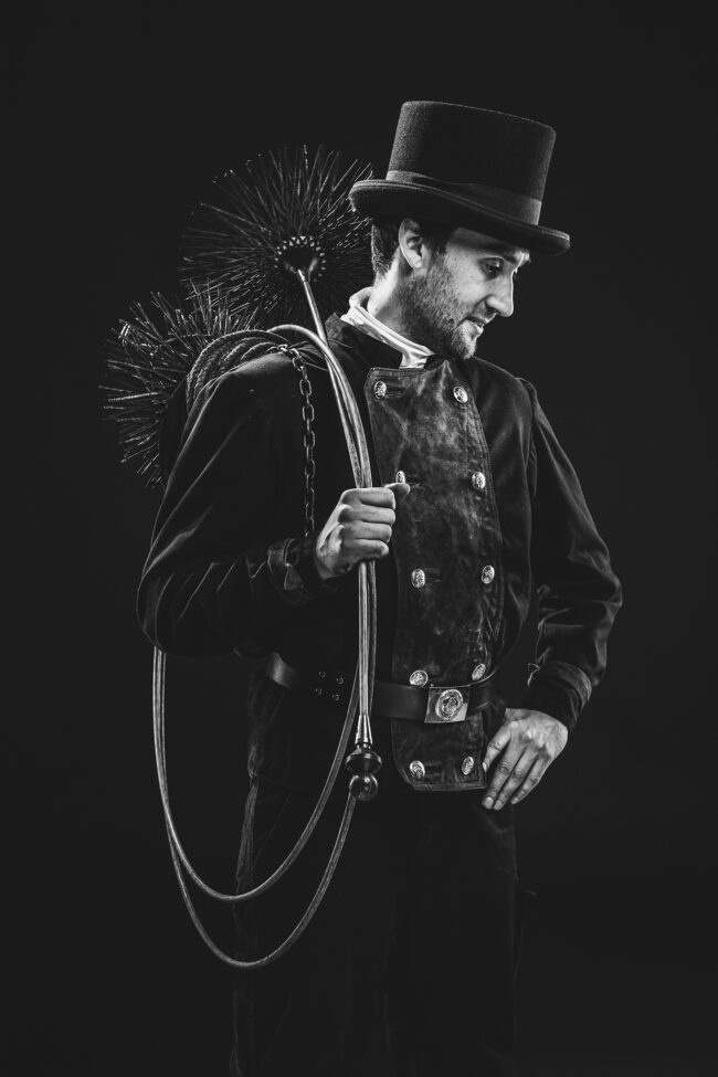 Portrait, Schornsteinfeger stehend in Arbeitskleidung mit Arbeitsgeräten, Schwarz-Weiß