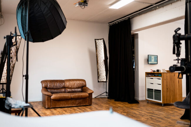 Studio Löchgau mit braunem Ledersofa und verschiedenen Blitzen