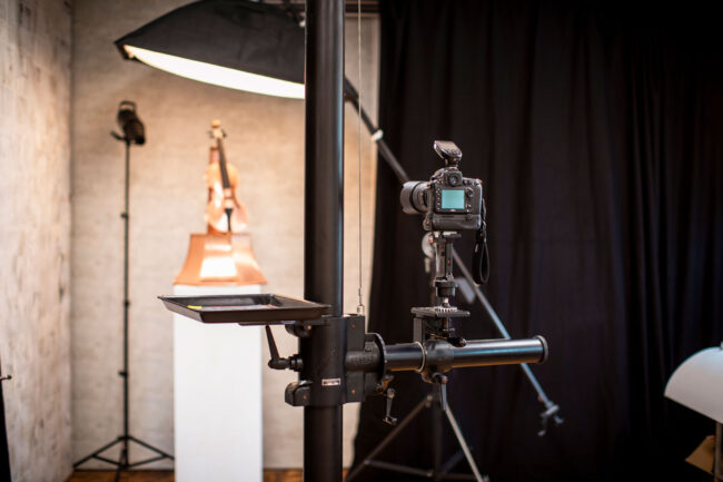 Studio Löchgau Produktfotografie, Kamerastativ mit Kamera, im Hintergrund eine Violine aus Kupfer