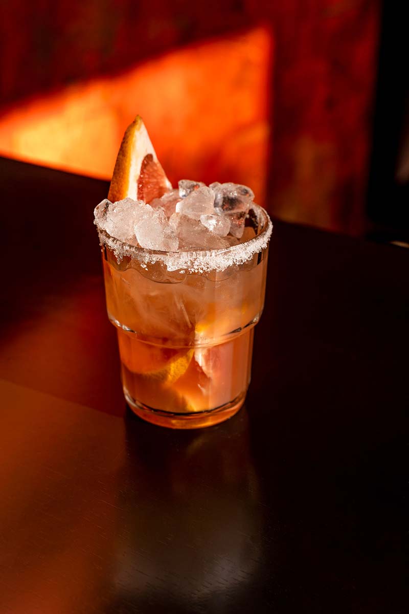 Cocktail auf dem Holztisch mit orangem Hintergrund im Alfons X.