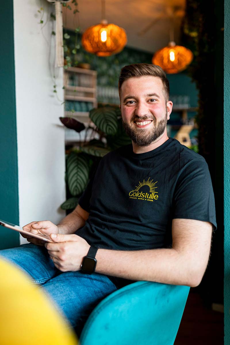 Mitarbeiter der Goldstulle sitzt auf einem Stuhl.