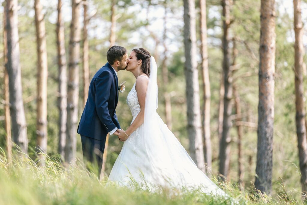 Brautpaar kuesst sich bei einem shooting im wald von loechgau.