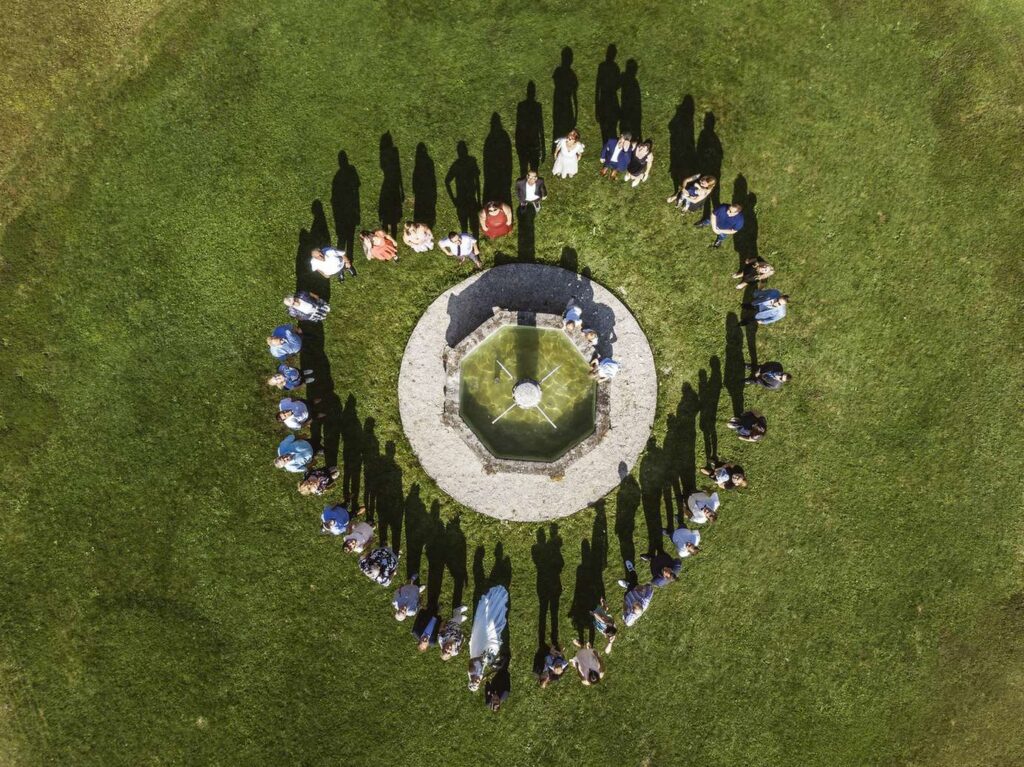 Gruppenfoto in herzform bei einer hochzeit von oben.