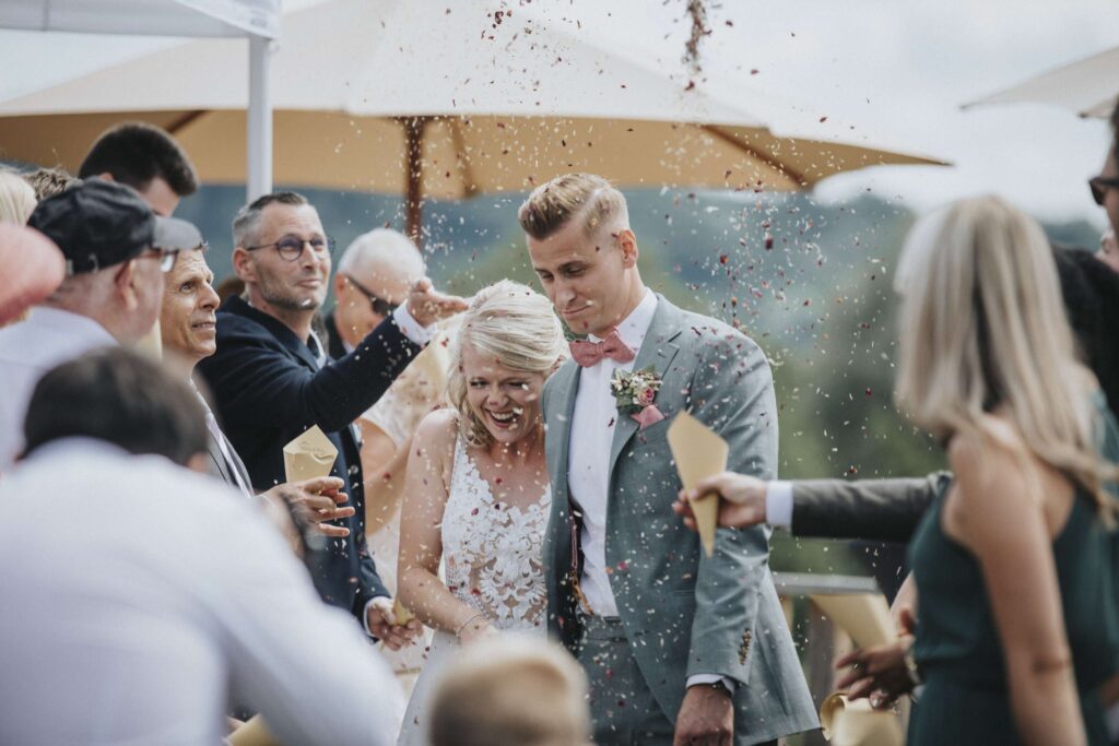 Hochzeitspaar bei der trauung mit gaesten im hintergrund.