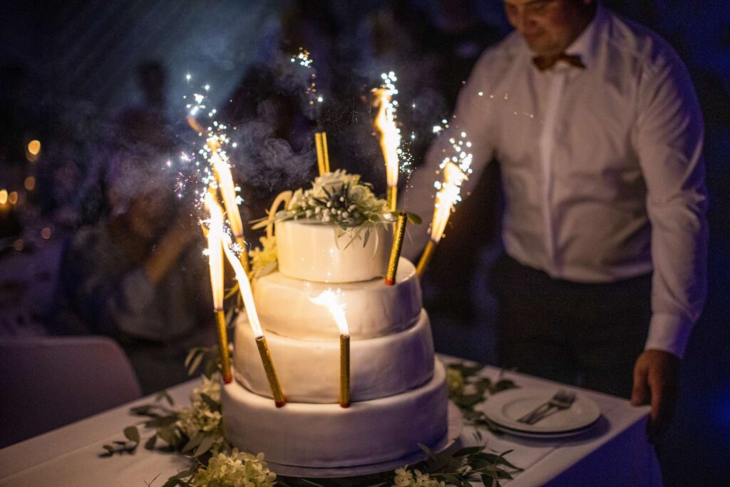 Hochzeitstorte mit brennendem feuerwerk auf einer party.