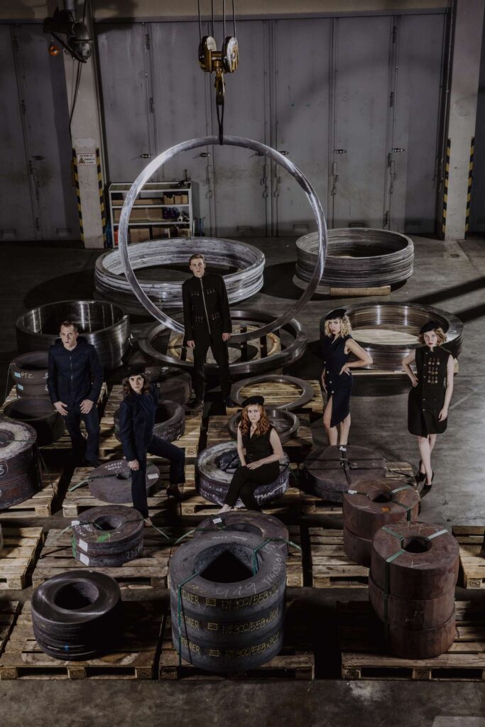 Modefotografie im industriellen Stil mit mehreren Personen in einer Lagerhalle.