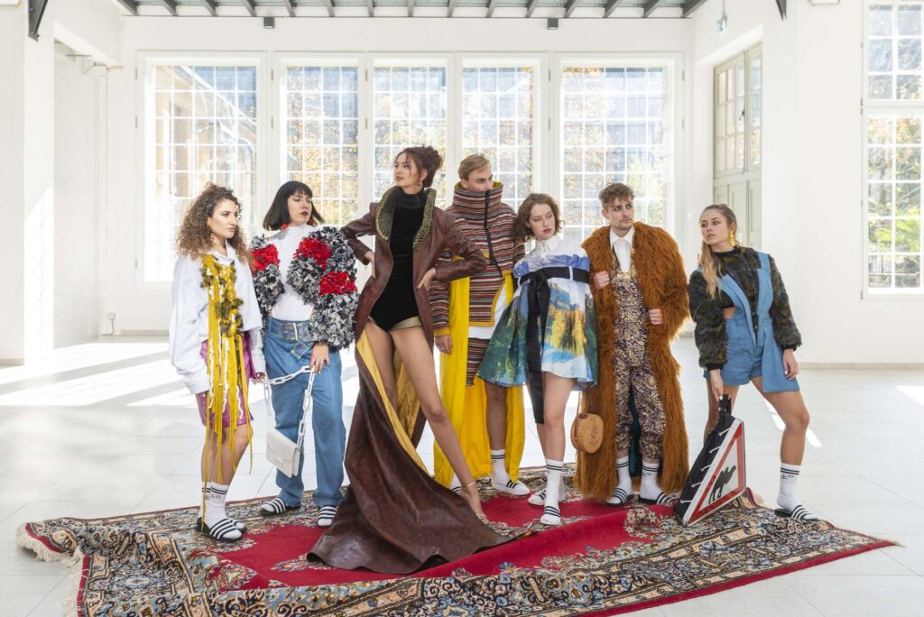 Eine Gruppe von Models in bunter Kleidung posiert in einem hellen Studio.