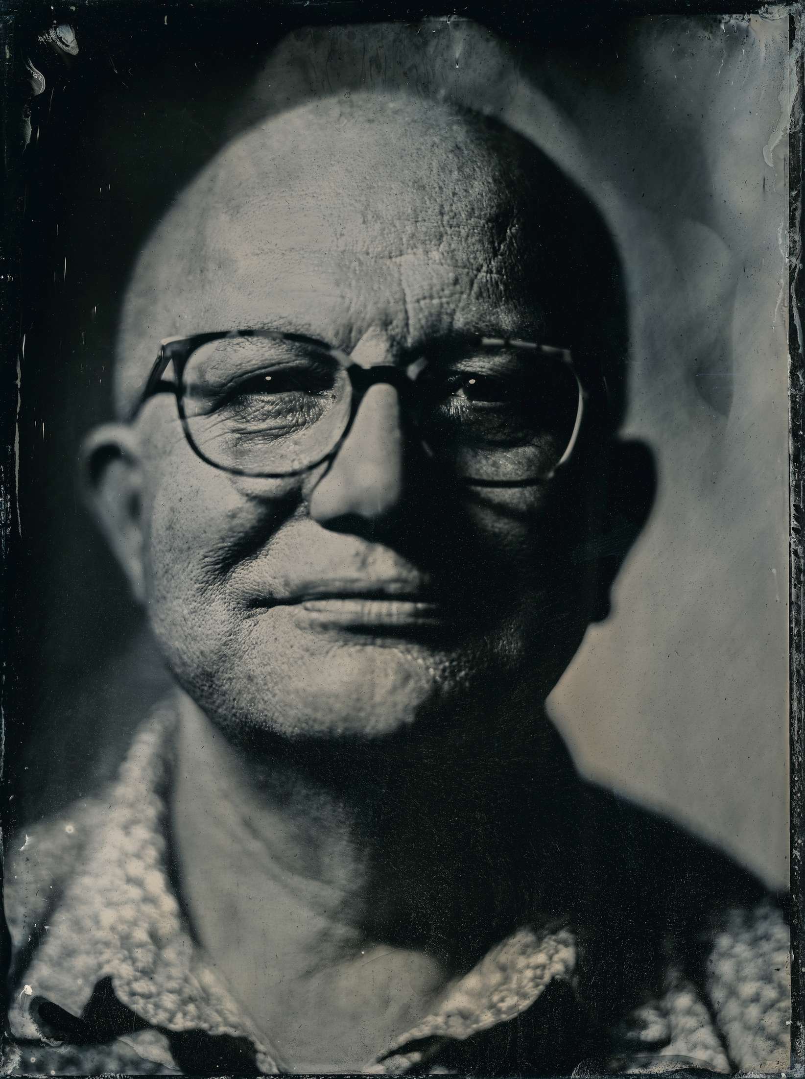 Ein aelterer Mann mit Brille in einer Nassplattenfotografie.