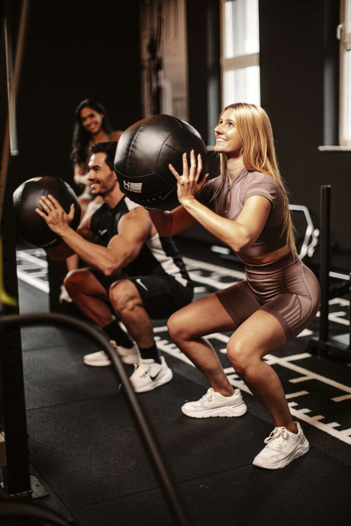 Menschen beim Training mit Medizinball in einem Fitnessstudio