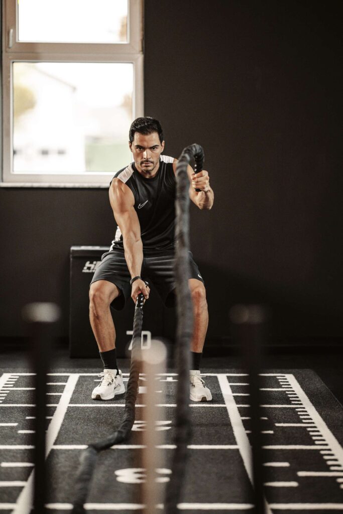 Person fuehrt ein intensives Seiltraining in einer modernen Fitnessumgebung durch.