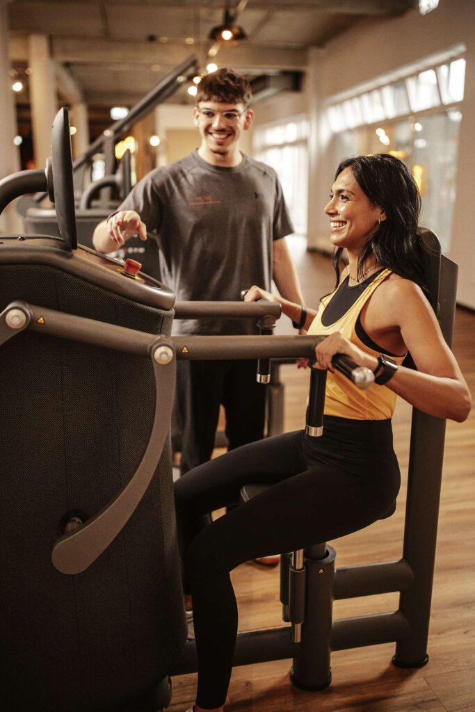 Personen trainieren an einem Fitnessgeraet im Move Kirchheim Therapie & Training Center.