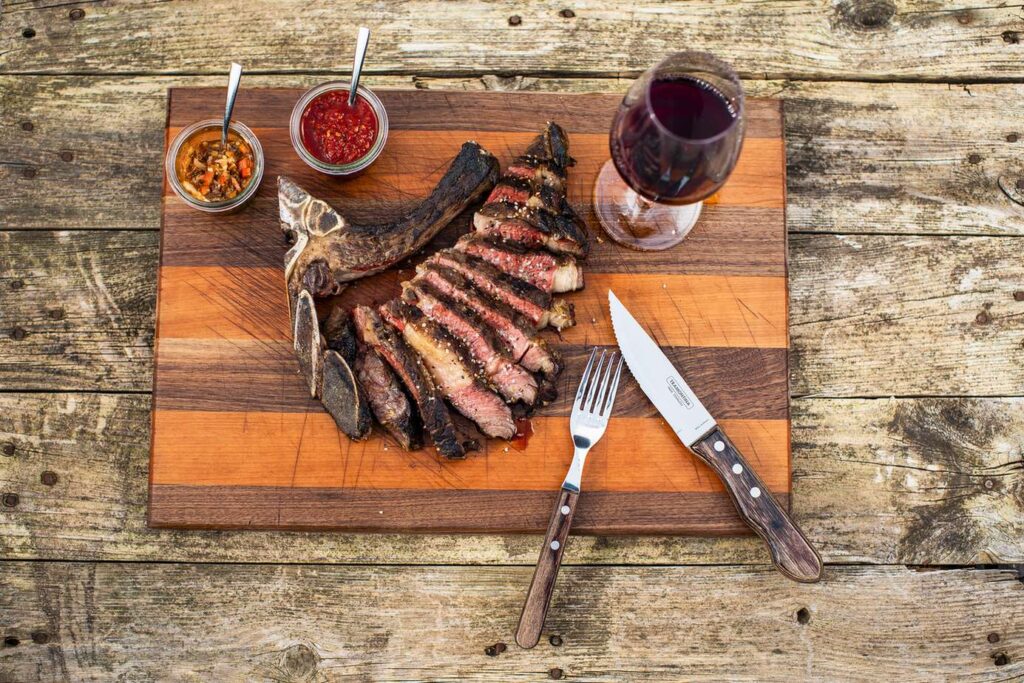 Rippchen auf Holzbrett mit Saucen und Getraenk