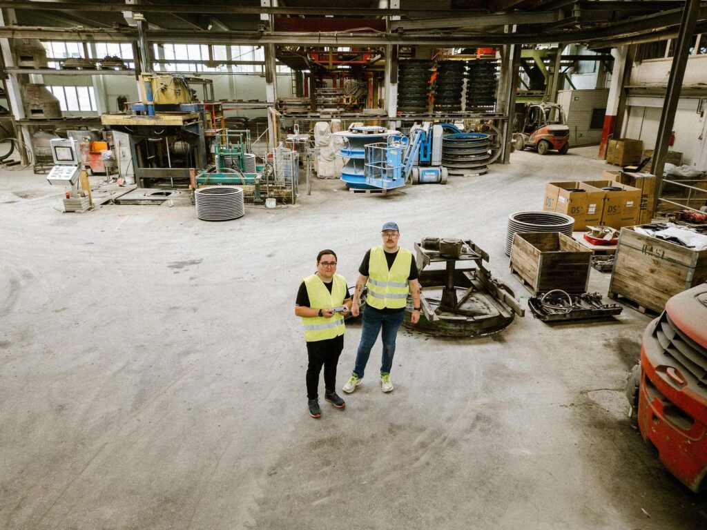 Personen-mit-Warnwesten-in-einer-Lagerhalle-stehend