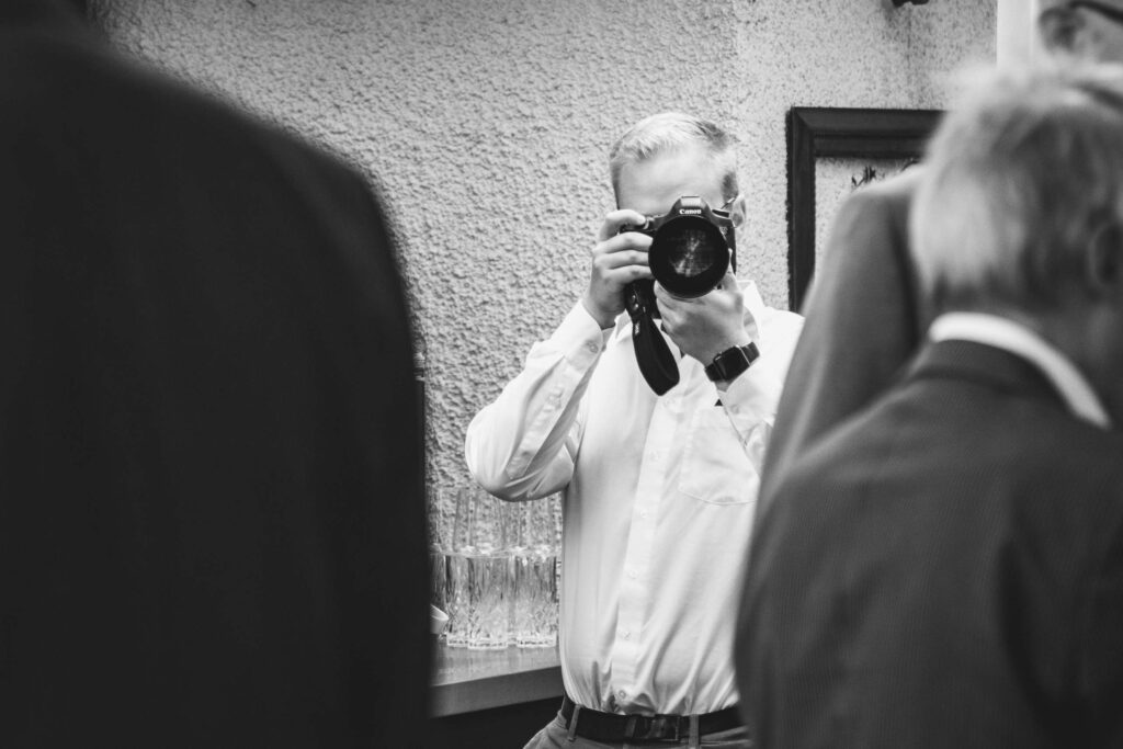 Ein Fotograf in Aktion bei einer Veranstaltung in Schwarz-Weiß.