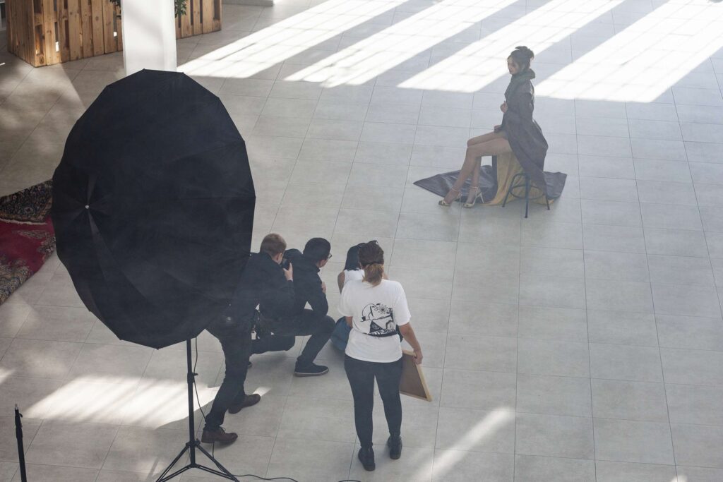 Fotografen bei Vorbereitungen fuer ein Fotoshooting in einem modernen Gebaeude.