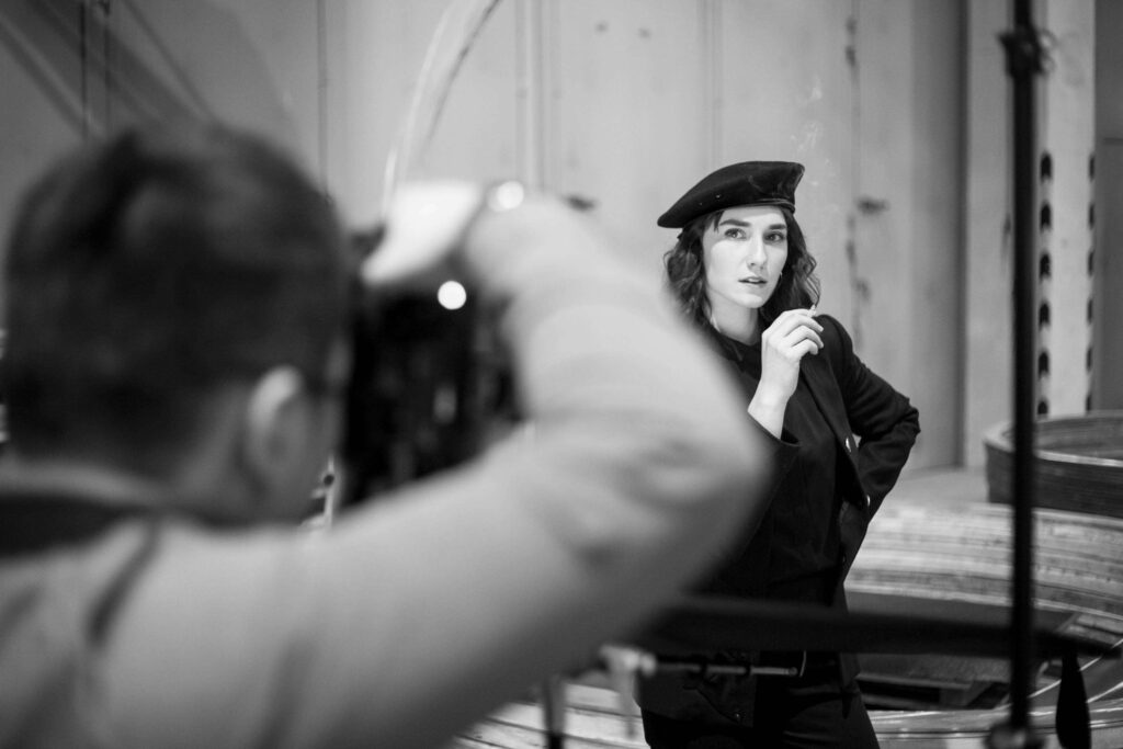 Fotograf macht ein Portraet einer Person mit Muetze.