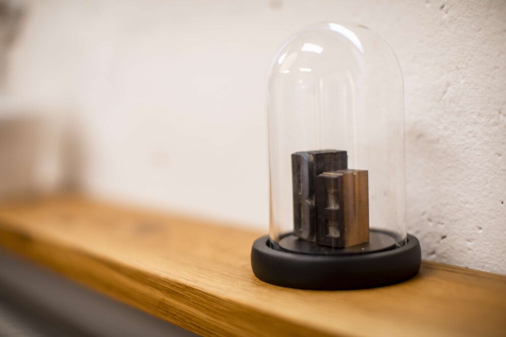 Dekoration im Studio von Befotomedia mit einer Glashaube auf einem Holztisch.