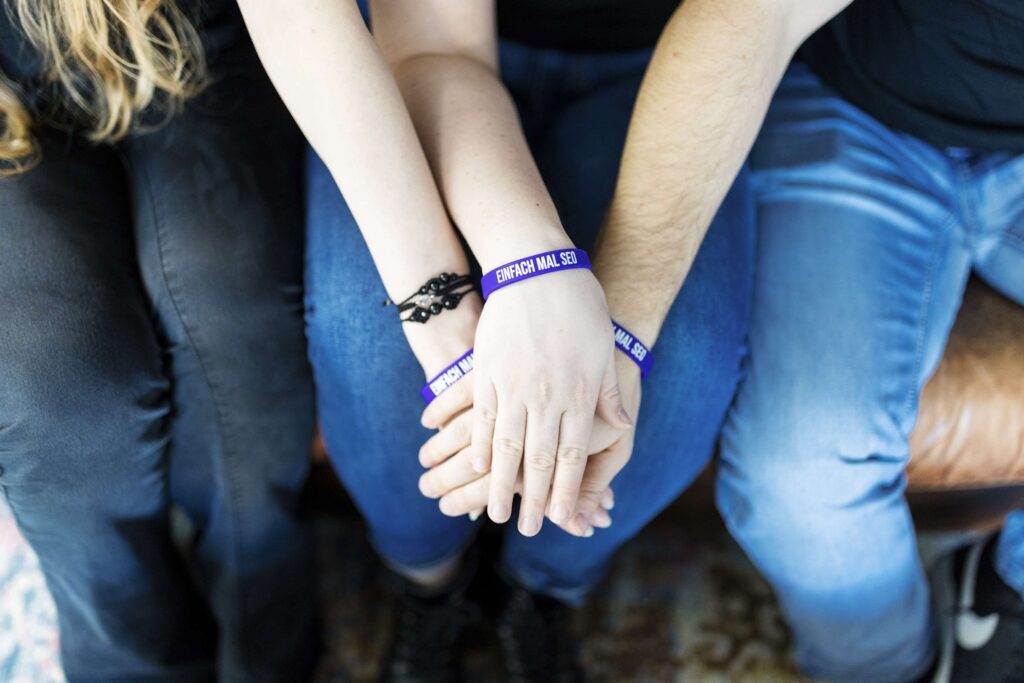 Teammitglieder von Einfach mal SEO halten symbolisch die Haende.