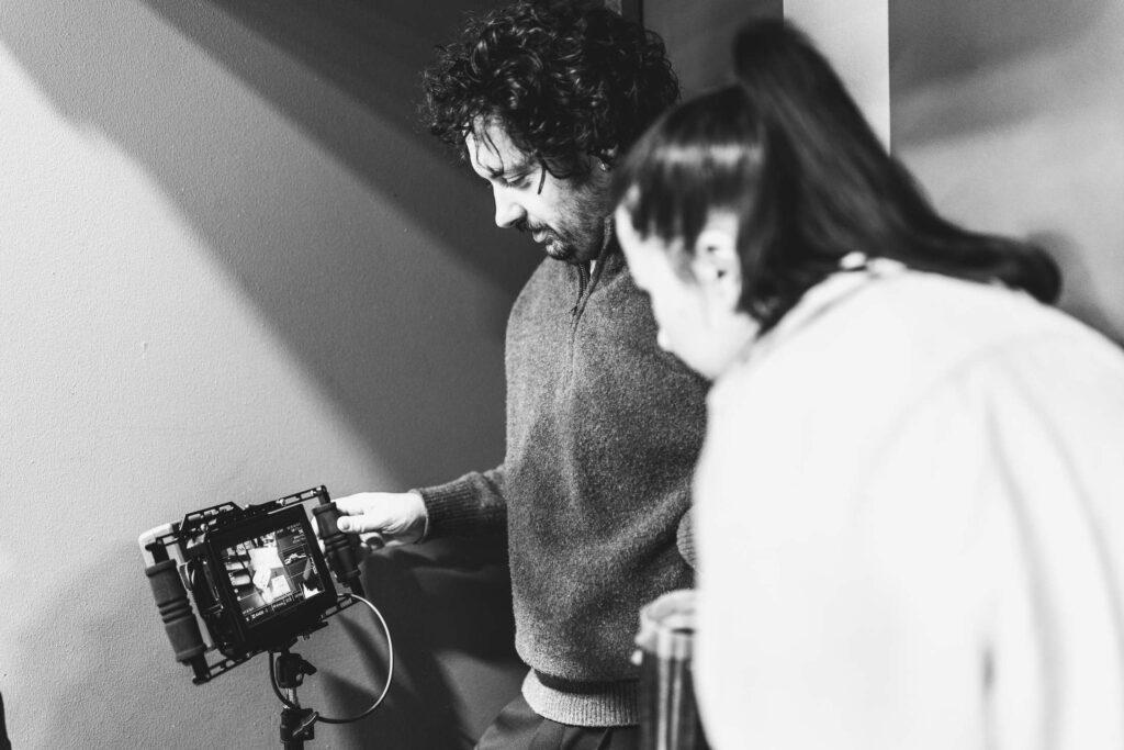 Zwei Personen betrachten ein Foto in einem analogen Fotoapparat.