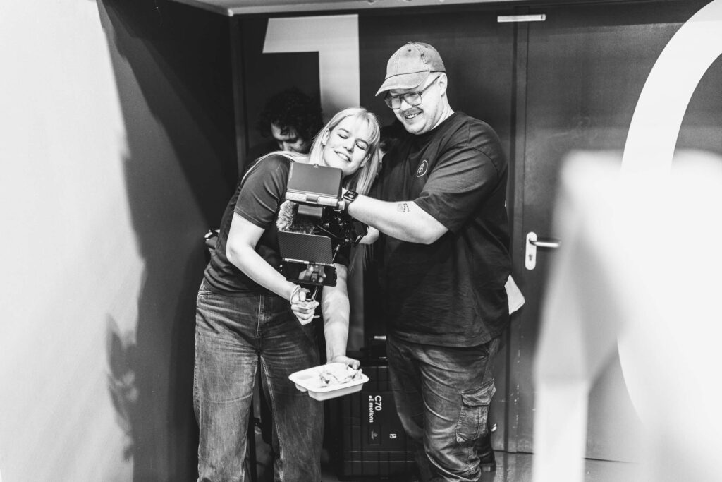 Zwei Personen bei einem Fotografie-Workshop mit einer Kamera.