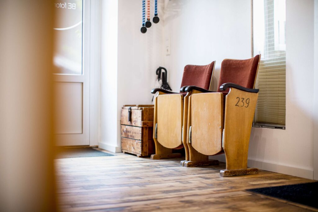 Ein Sitzbereich im Fotostudio von Befotomedia mit Vintage-Stuehlen und Holzboden.