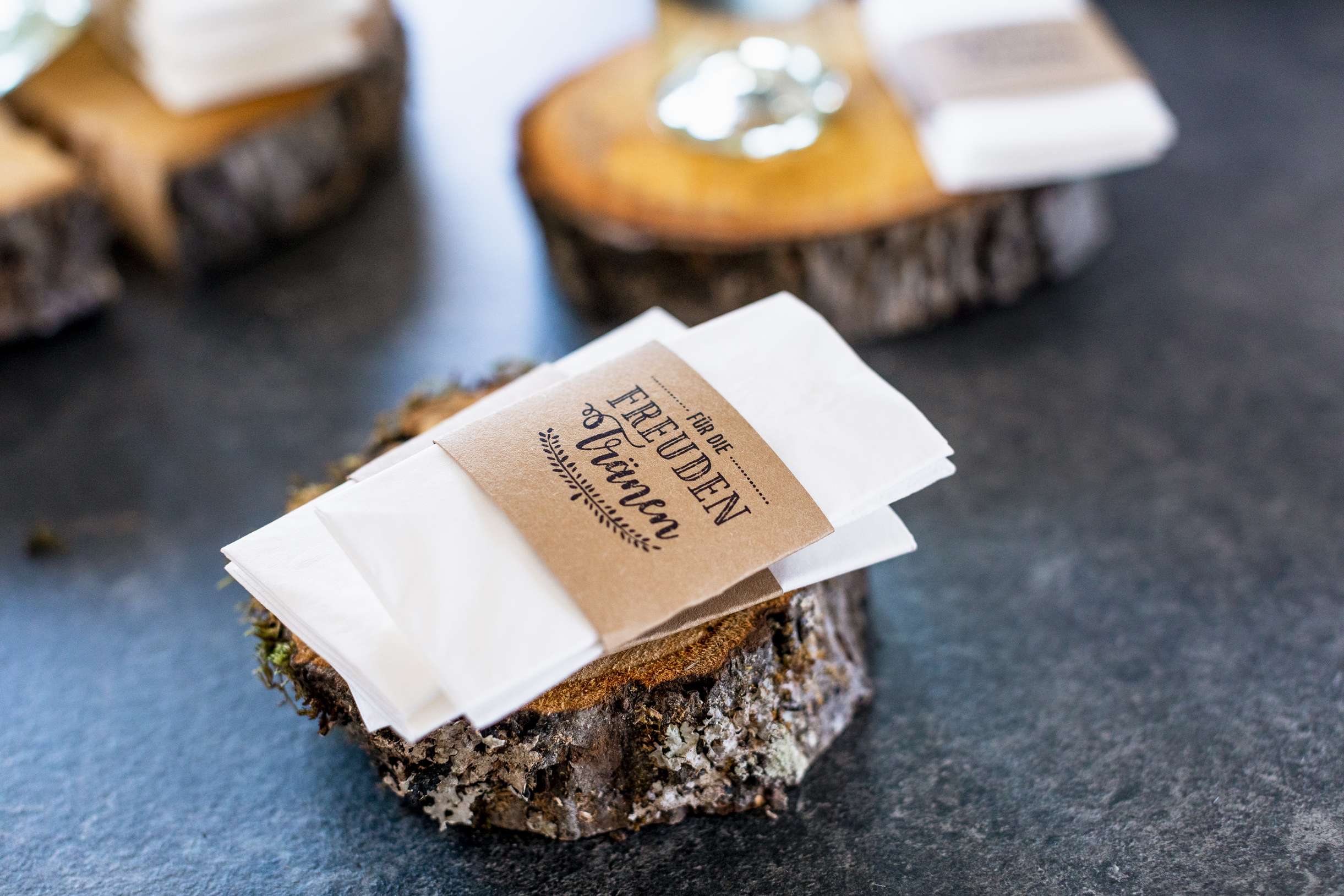 Rustikale Namensschilder aus Holzstuecken fuer eine Hochzeitstafel.