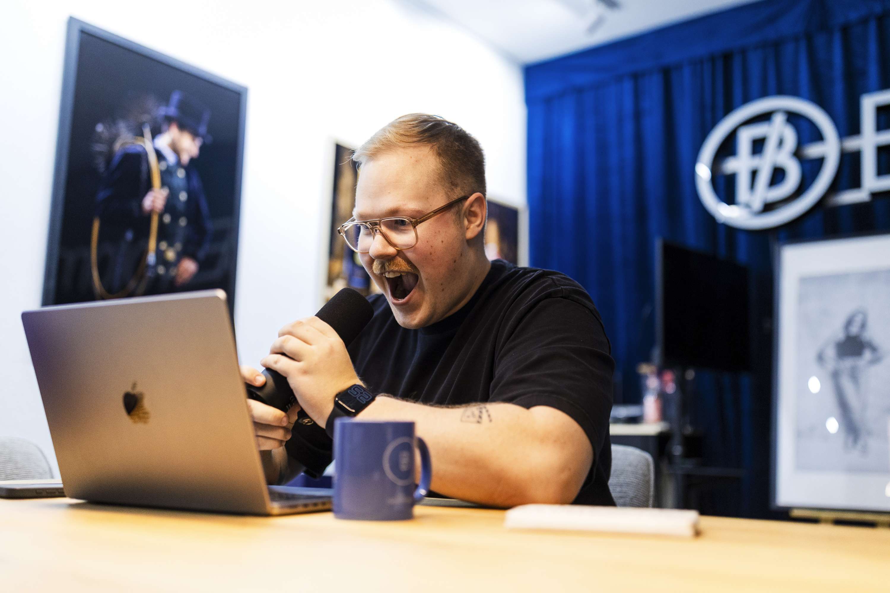 Person sitzt an einem Tisch, arbeitet am Laptop und schaut konzentriert.