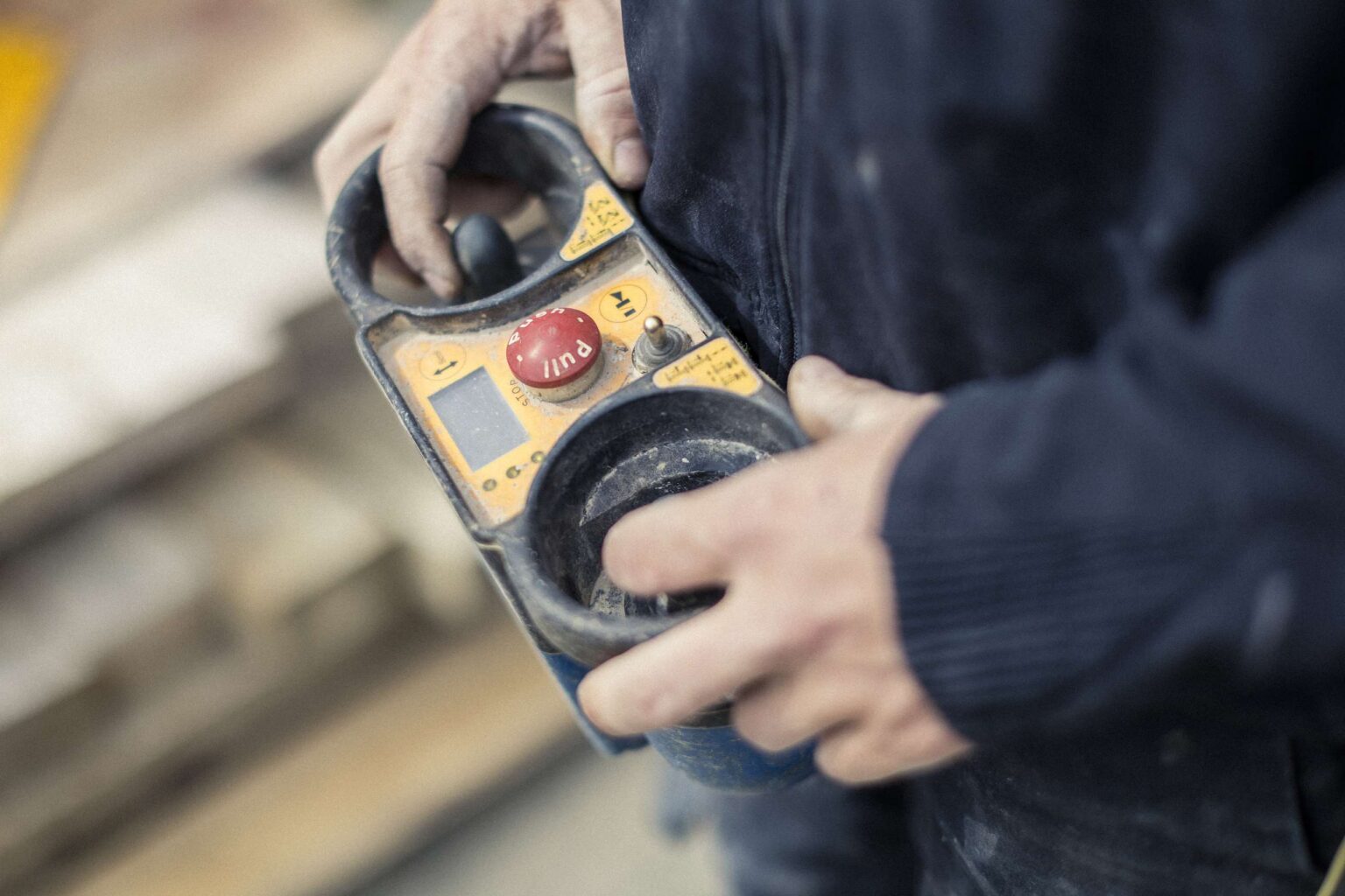 Ein Bauarbeiter bei Rudolf-Bau haelt eine Fernsteuerung.