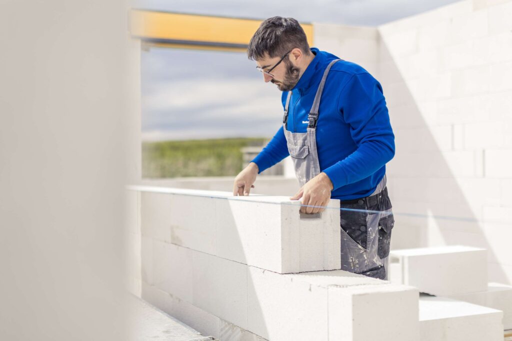 Ein Bauarbeiter von Rudolf-Bau bei der Arbeit an einer Mauer in Obermarchtal.